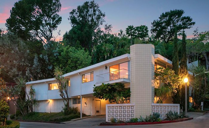 Classic Beverly Hills Mid Century home with pool is set in a lush, verdant setting among mature trees.